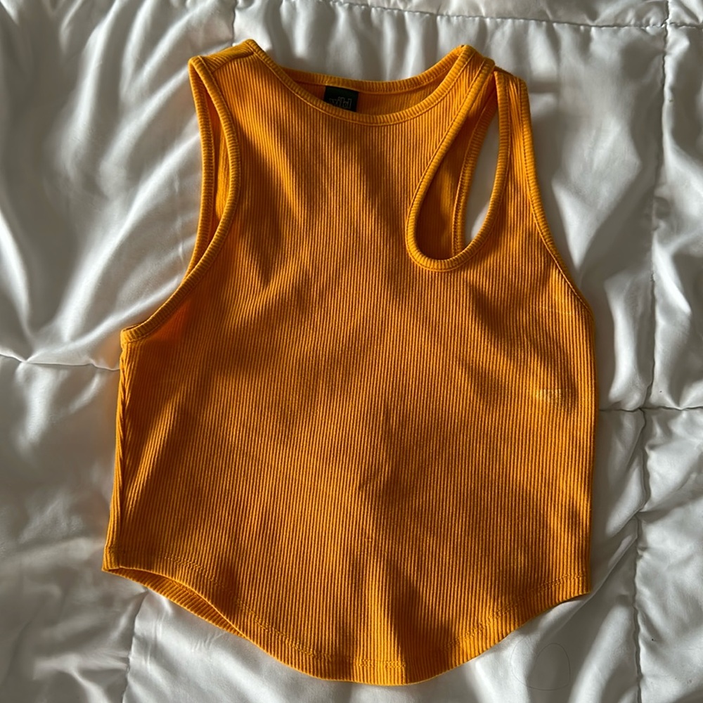 Orange tank top with open slit in the shoulder.